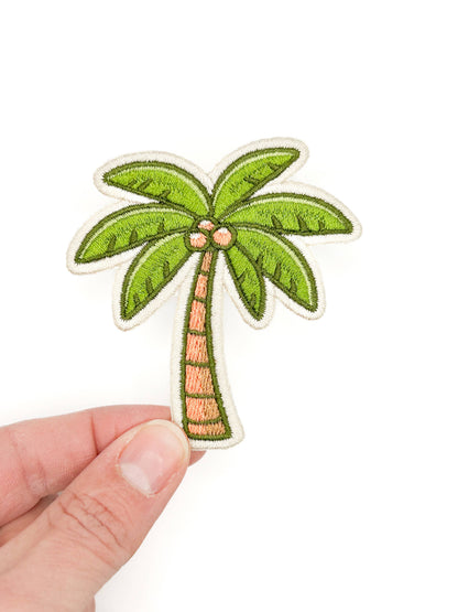 Embroidered iron-on patch of a green palm tree with a brown trunk