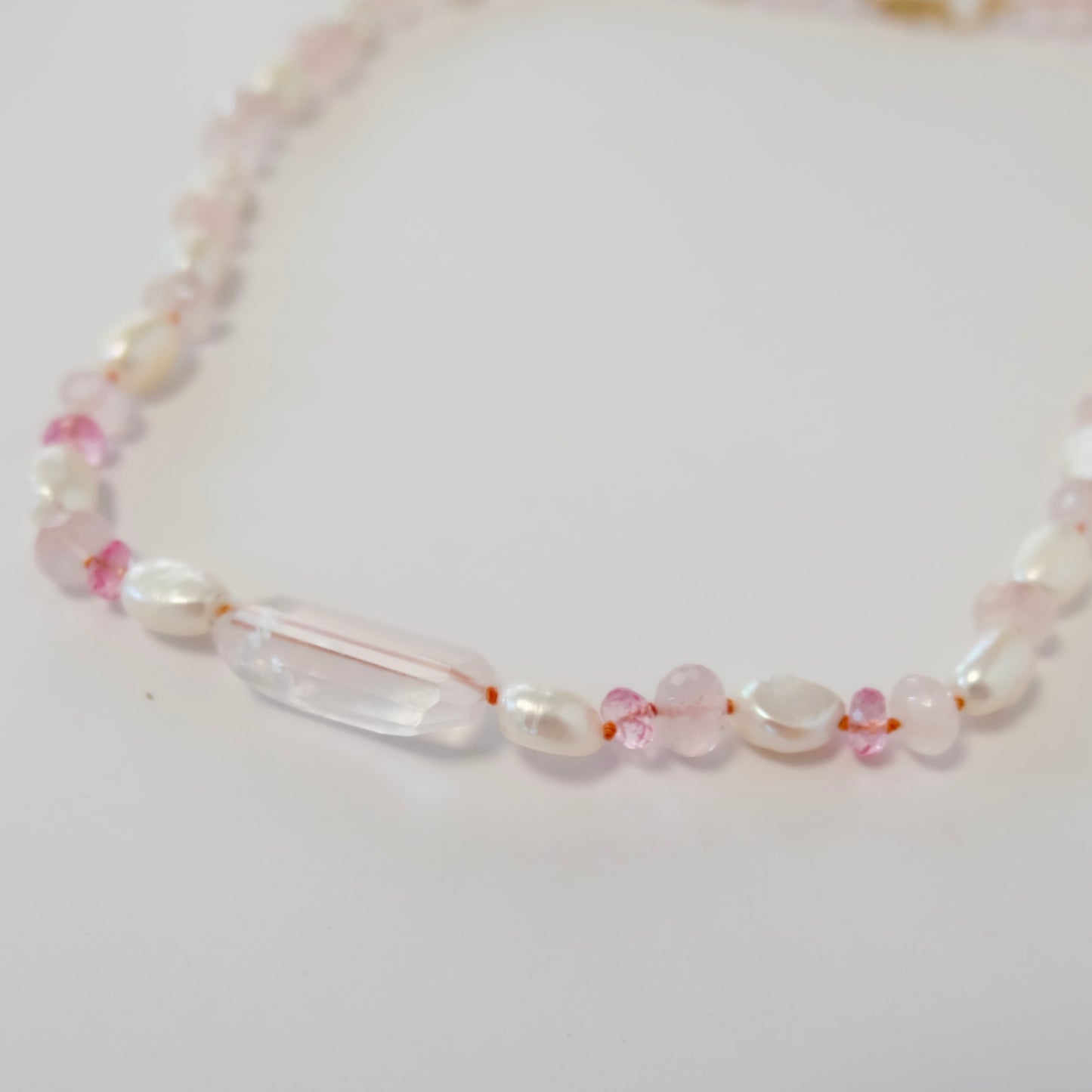 A delicate necklace featuring pink topaz, rose quartz, and pearl, exuding elegance and charm in a candy-inspired design.
