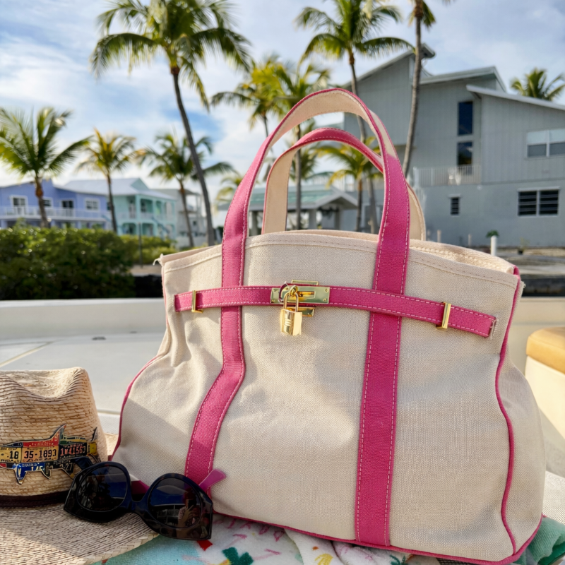 Pink Boatkin bag on a boat deck with palm trees in the background