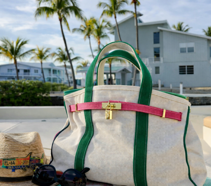Pink and green Boatkin on a boat deck with palm trees and houses in the background.