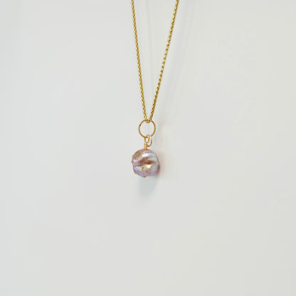 Close-up of a pink rosebud freshwater pearl with purple iridescence