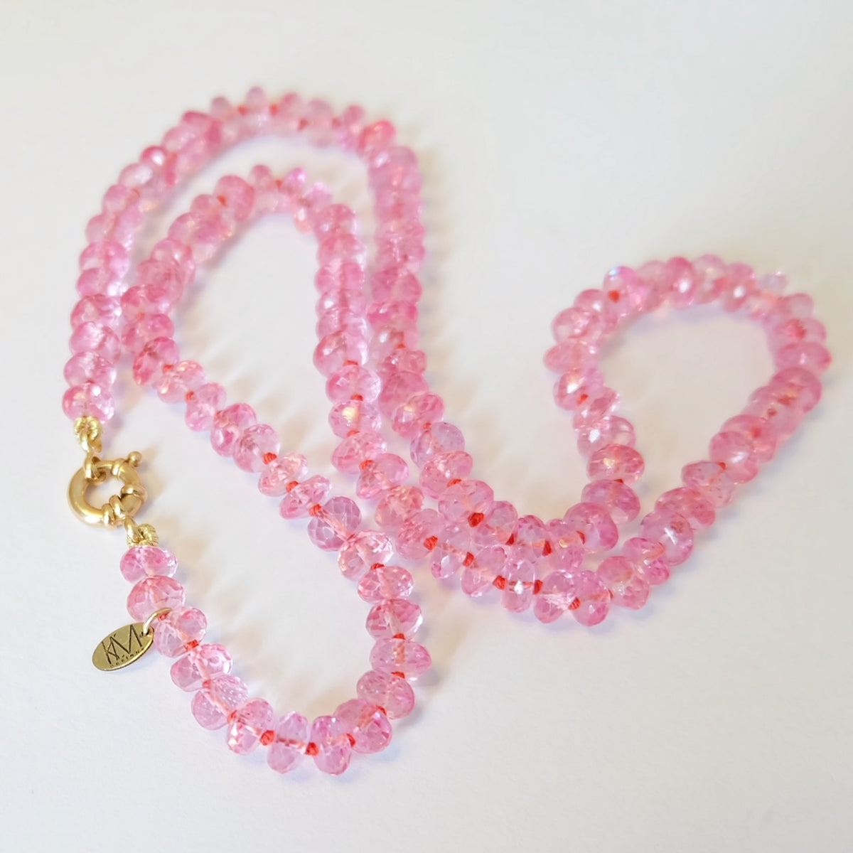 Pink topaz candy necklace with a solid 14K gold lobster clasp and quality tag
