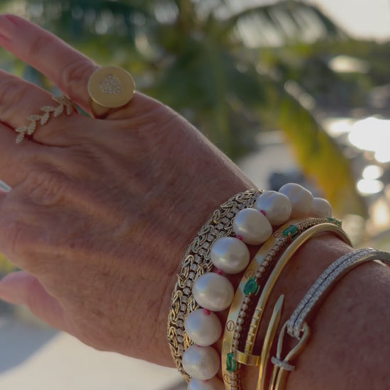 Elegant potato pearl bracelet with pink silk knots, a sterling silver clasp, and a dangling pink topaz and pearl charm.