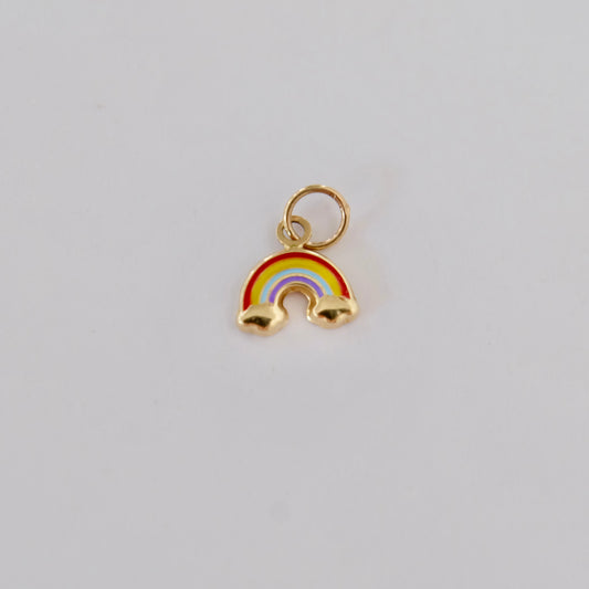 A whimsical 14k gold charm featuring a rainbow design, symbolizing joy and beauty in a compact form.
