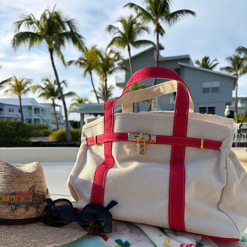 Red Boatkin bag on a boat deck with palm trees and houses in the background