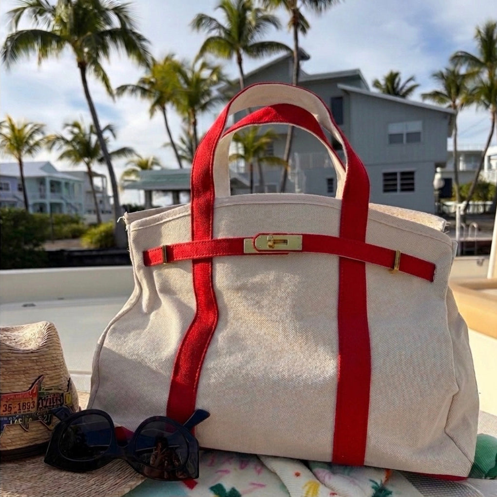 Red Boatkin bag on a boat deck with palm trees and houses in the background