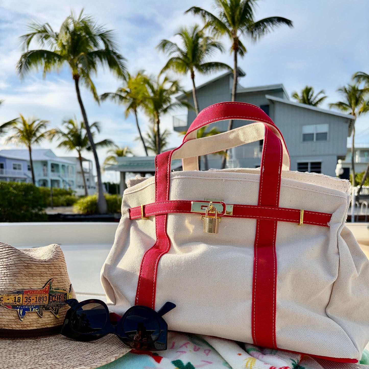 Read Boatkin tote bag on a boat deck with palm trees and houses in the background