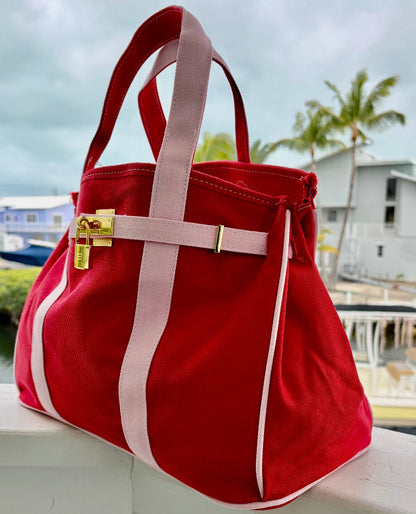 Close-up of red and pink Boatkin tote bag showing gold lock and handles