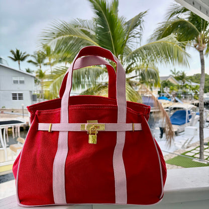 Red and pink Boatkin with palm trees and boats in the background.