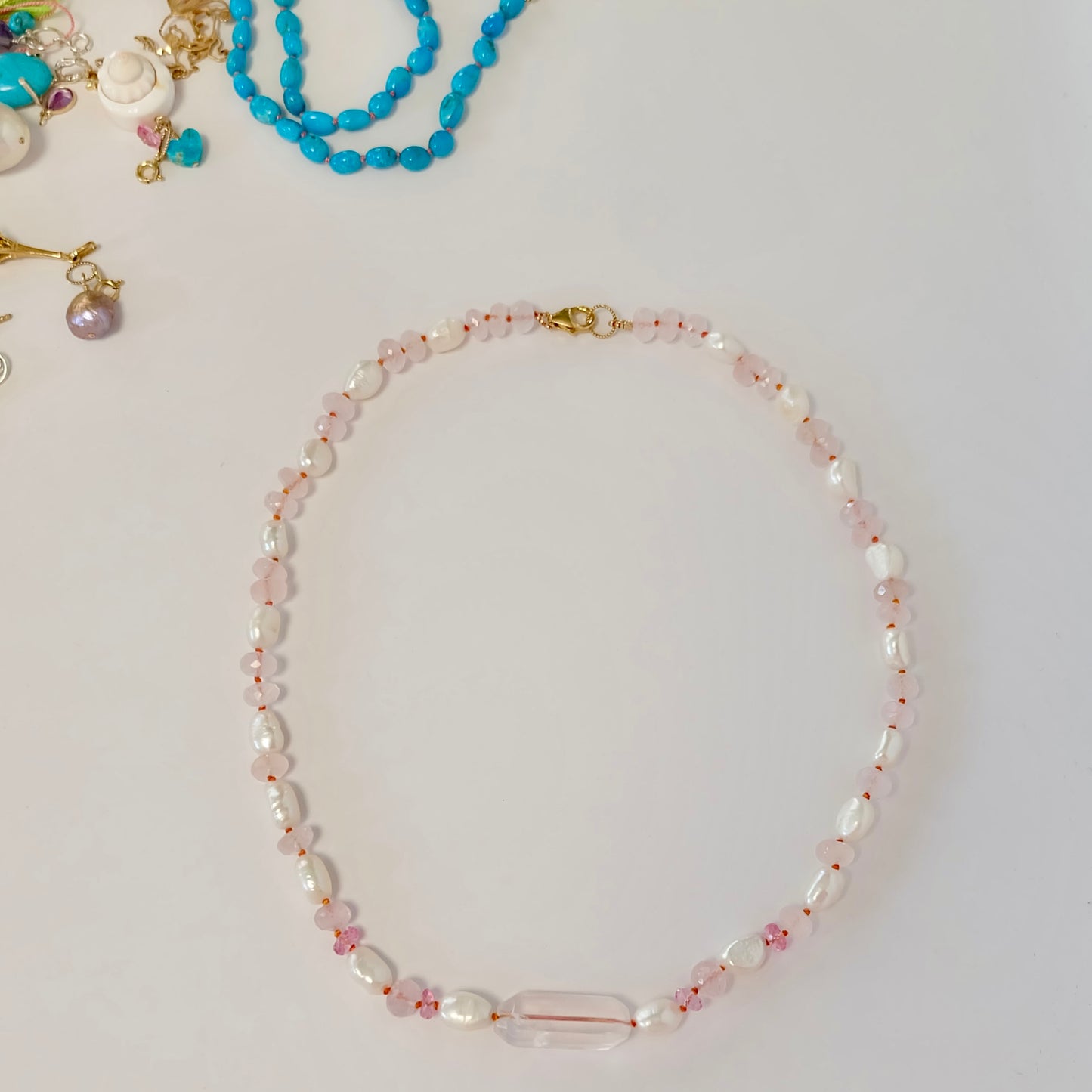 A beautiful necklace combining pink topaz, rose quartz, and pearl, designed to evoke a sense of playful elegance.