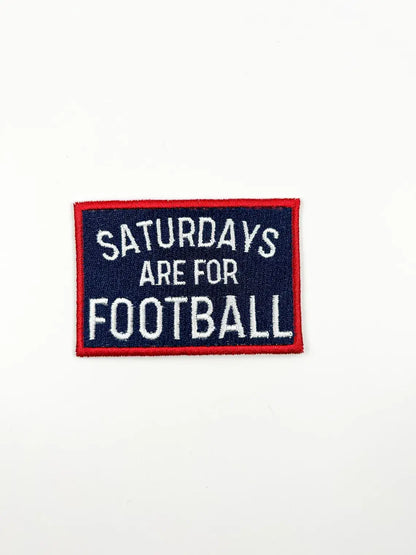 A rectangular embroidered patch with a navy blue background, red border, and white text reading 'SATURDAYS ARE FOR FOOTBALL' on a plain white background.