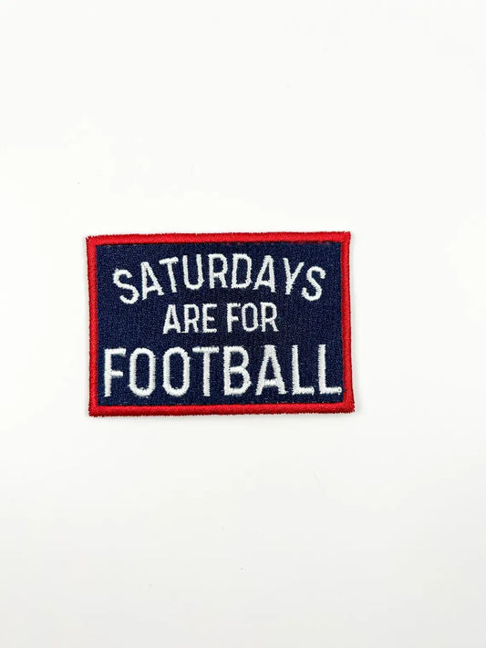 A rectangular embroidered patch with a navy blue background, red border, and white text reading 'SATURDAYS ARE FOR FOOTBALL' on a plain white background.