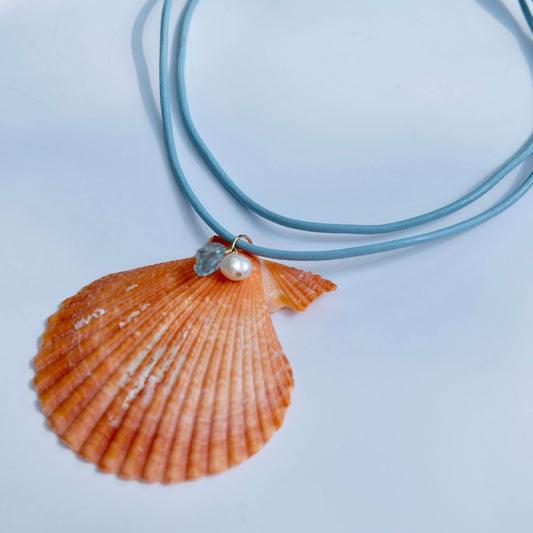 Close up of sea shell pendant necklace with aquamarine