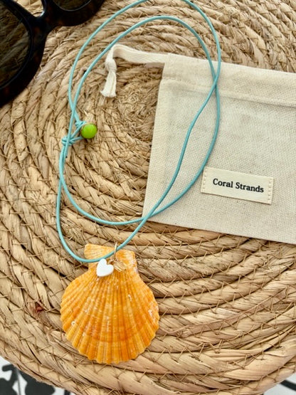 Sea shell pendant necklace with orange fan-shaped shell close-up