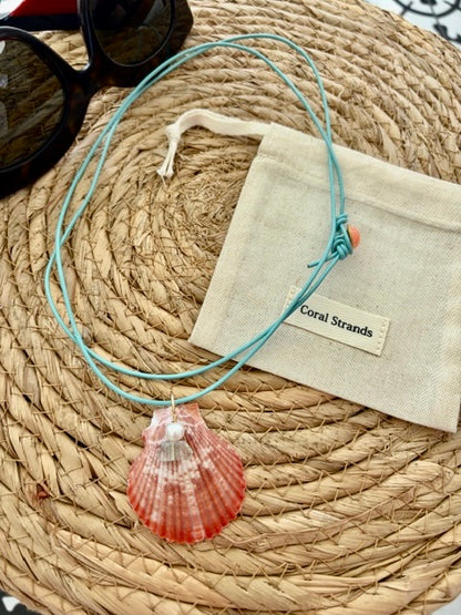 Sea shell pendant necklace with pink shell close-up on woven mat
