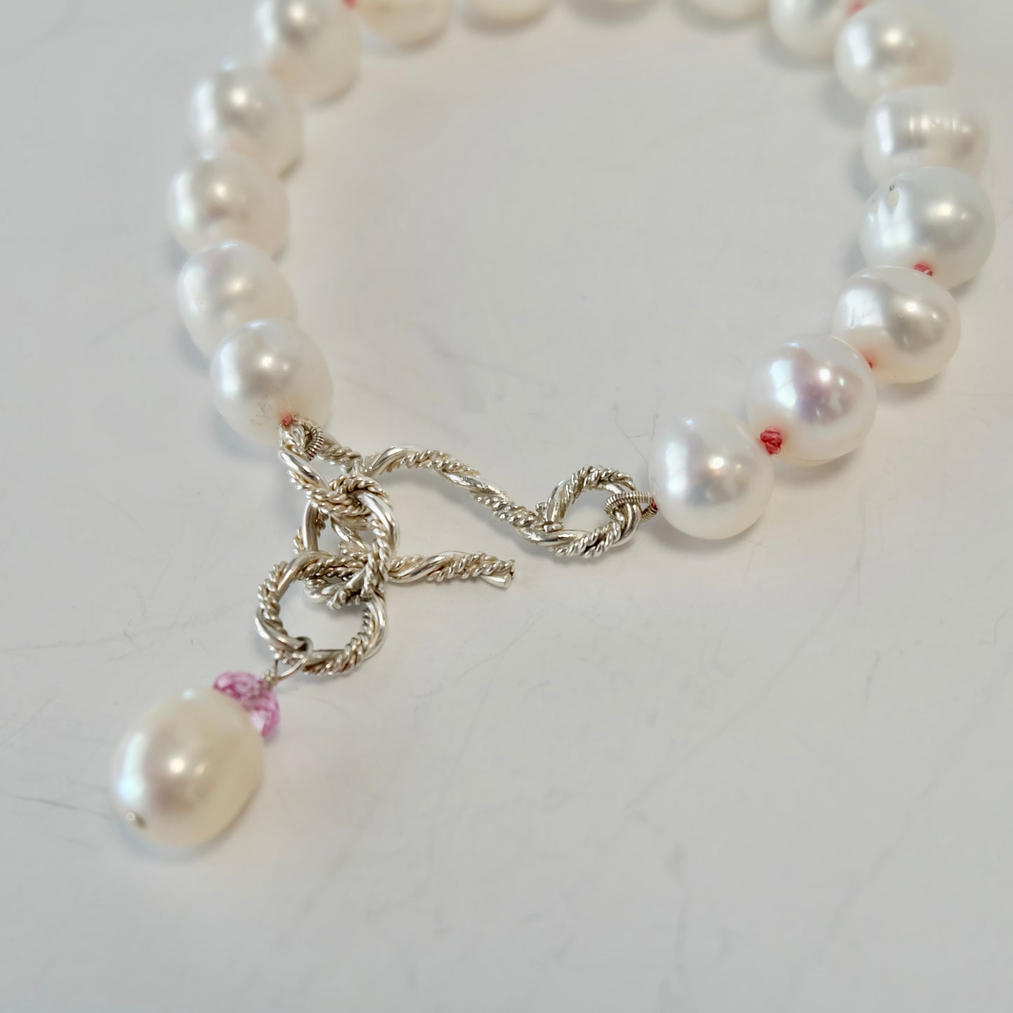 Silver and pearl bracelet with a pin topaz  chain and S clasp on a white background