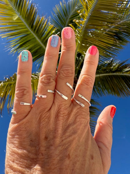 A sleek silver bypass ring featuring a modern design with intertwined bands.