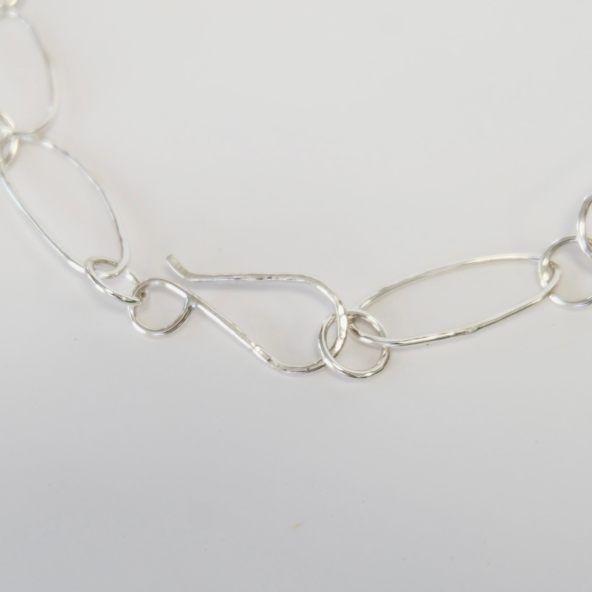 A stylish silver link necklace composed of interconnected links, ideal for enhancing both casual and formal attire.
