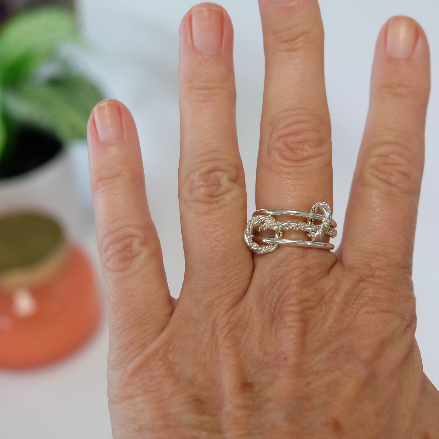 A dynamic Solarium ring featuring three thin bands and connectors, designed for versatile wear on one or multiple fingers.