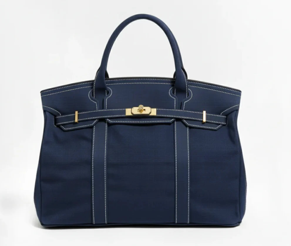 Solid navy blue boatkin tote bag with gold hardware on a white background
