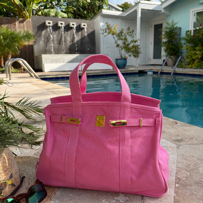 Solid pink Boatkin bag open by a pool.