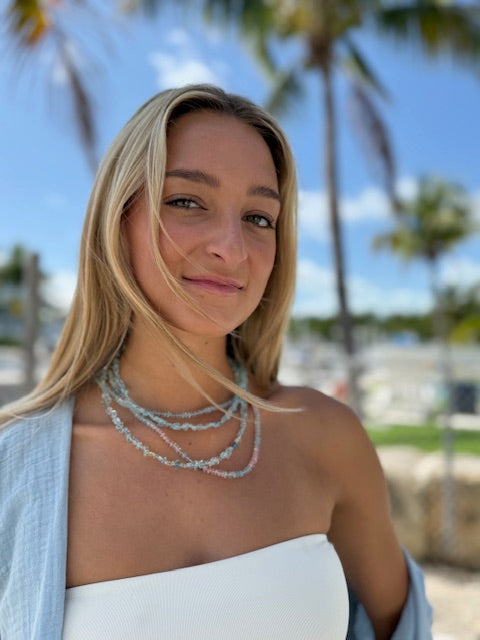 woman wearing stacked layered necklaces