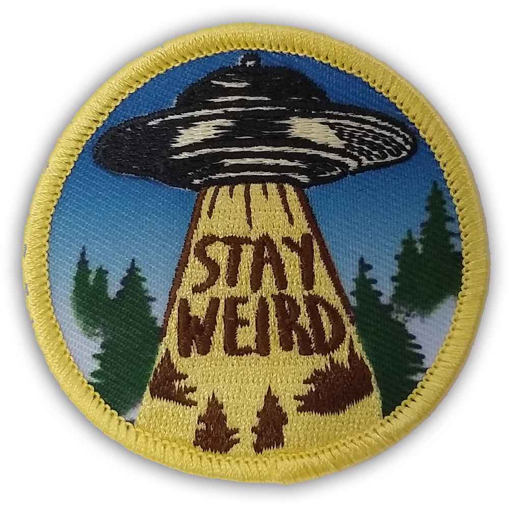 Stay weird embroidered iron on patch  with UFO design on a blue background with trees.