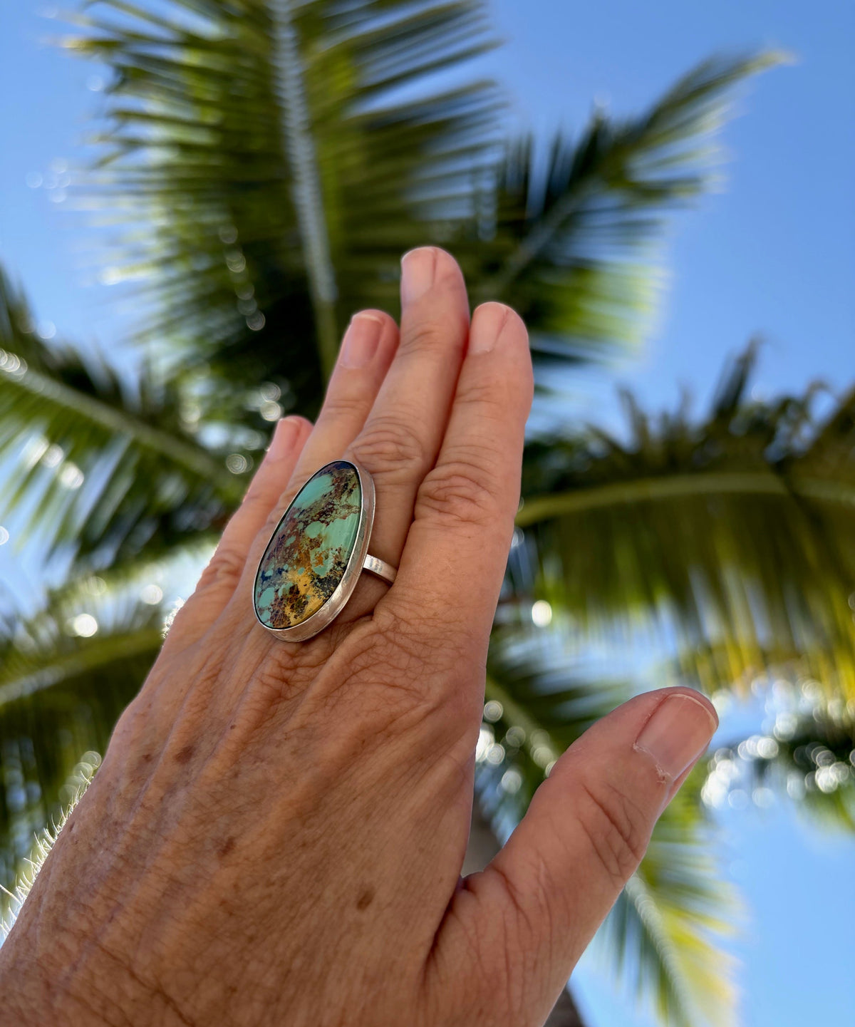 Woman wearing the Stella Blue turquoise silver ring with a black dress