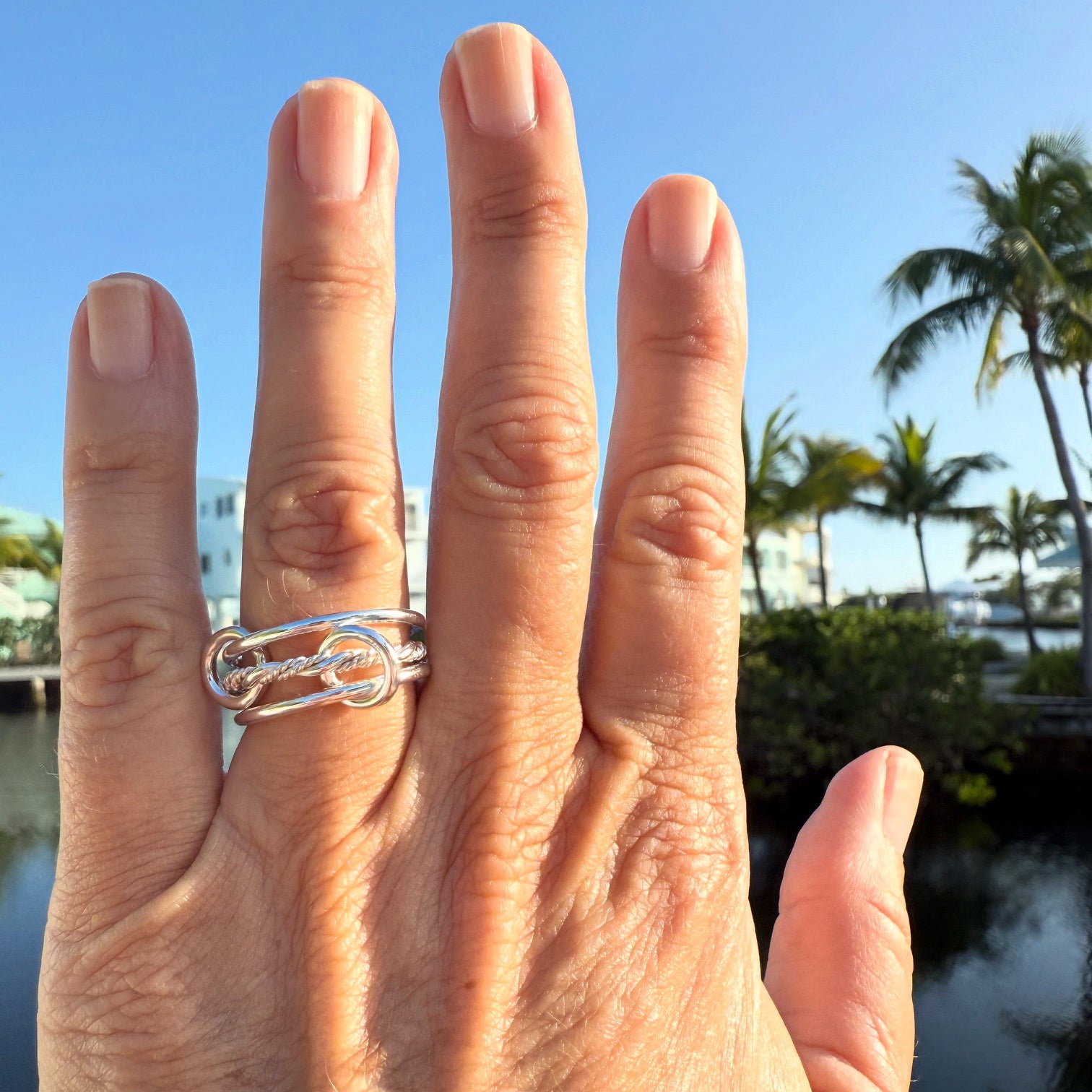Hand wearing a sterling silver braided interlocking ring