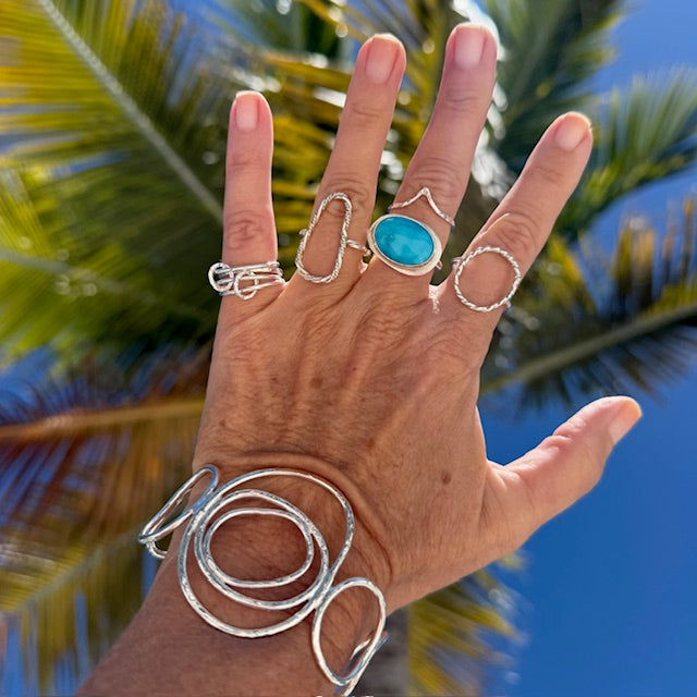 Woman's hand wearing a sterling silver ring collection.