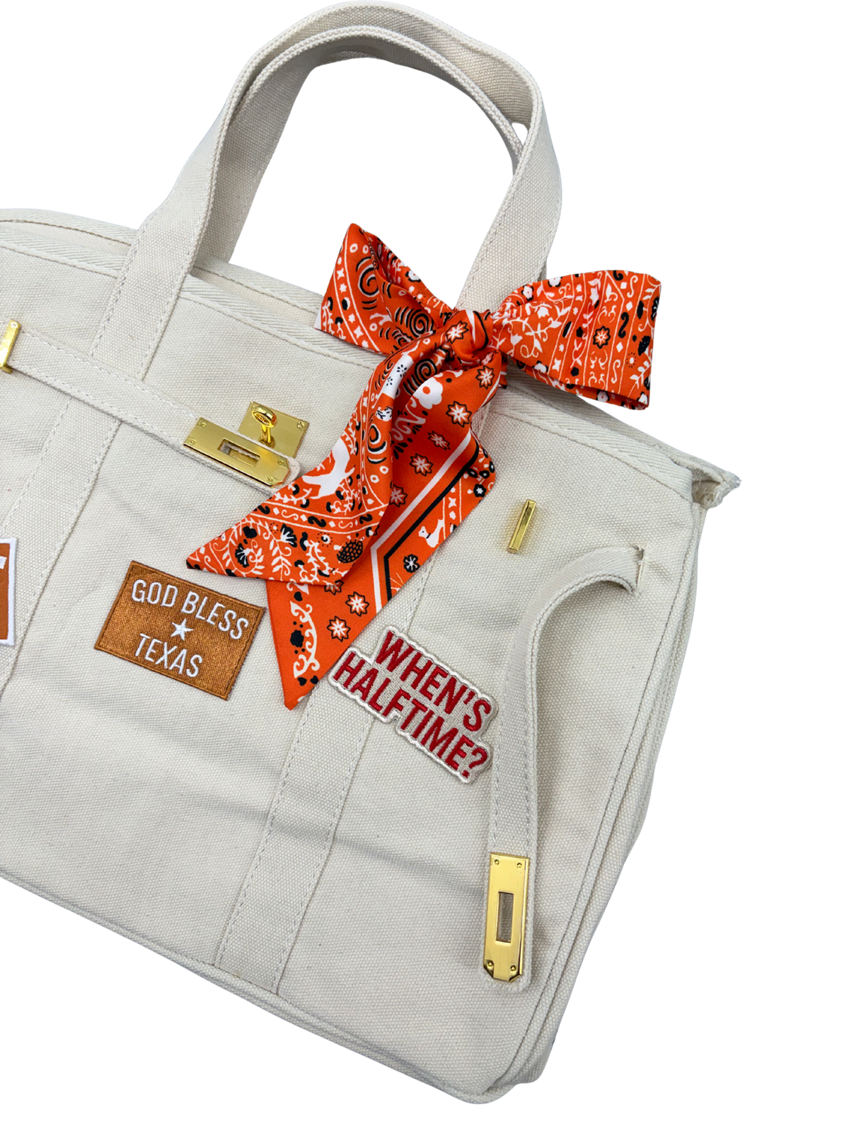 Detailed right side view of the cream Texas Longhorns canvas weekender tote bag highlighting a vibrant orange paisley twilly scarf and an embroidered When’s Halftime patch.