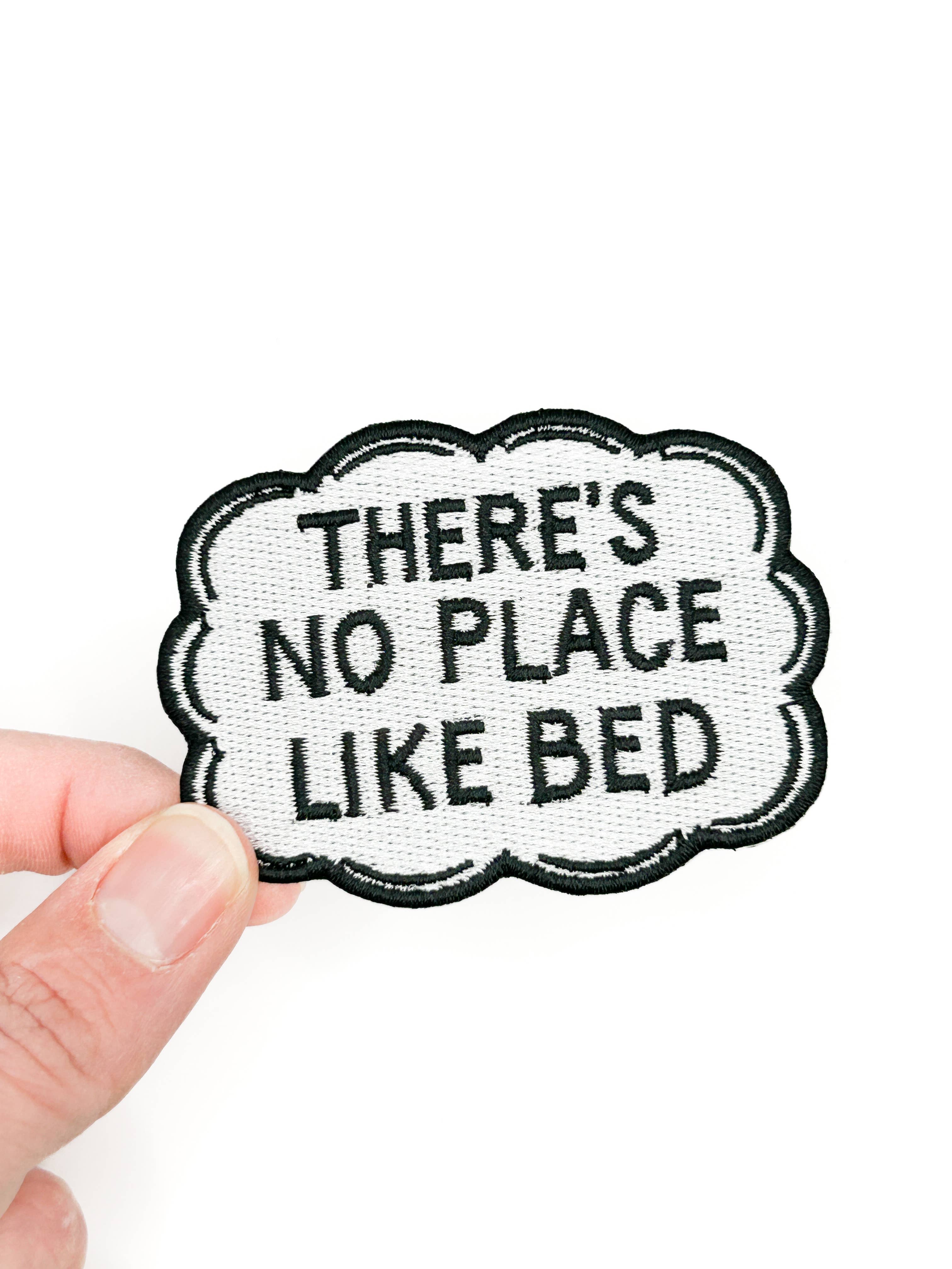 There's No Place Like Bed embroidered iron on patch, black lettering with cloud border, 2x2.75 inches