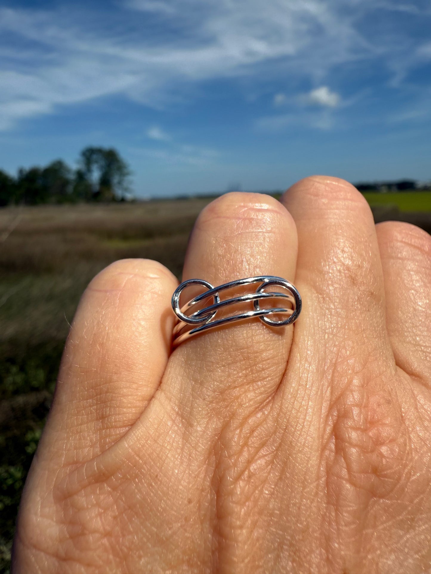 Hand showing thin interlocking ring close up