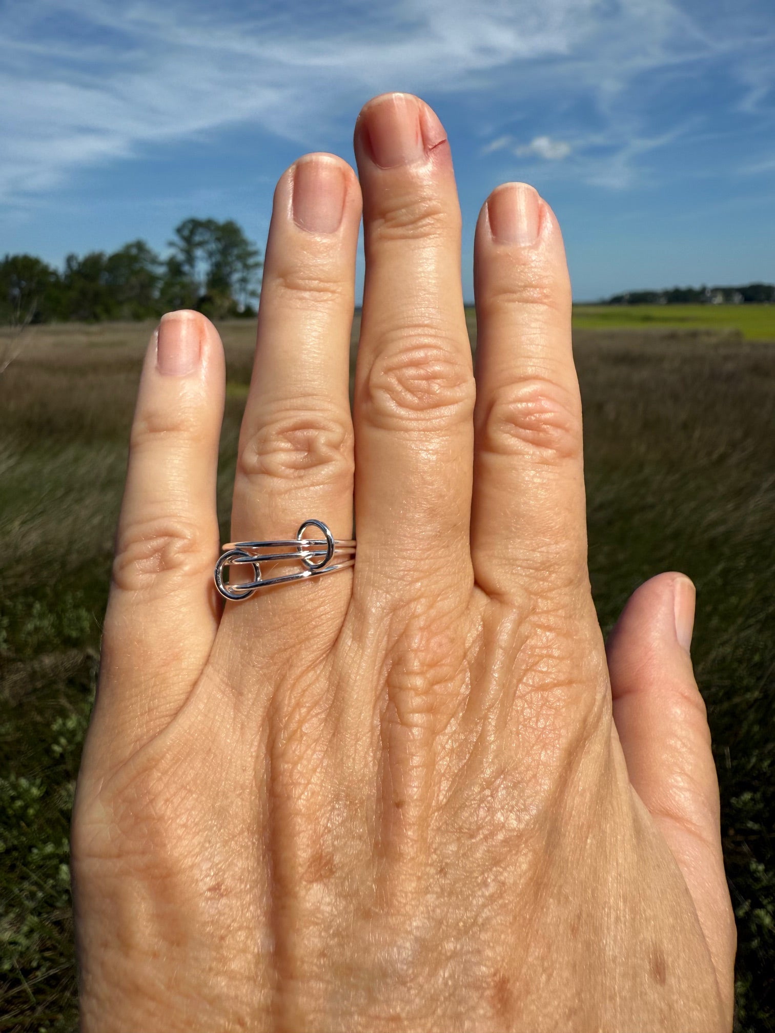 Hand showing thin interlocking locking ring with sterling silver bands