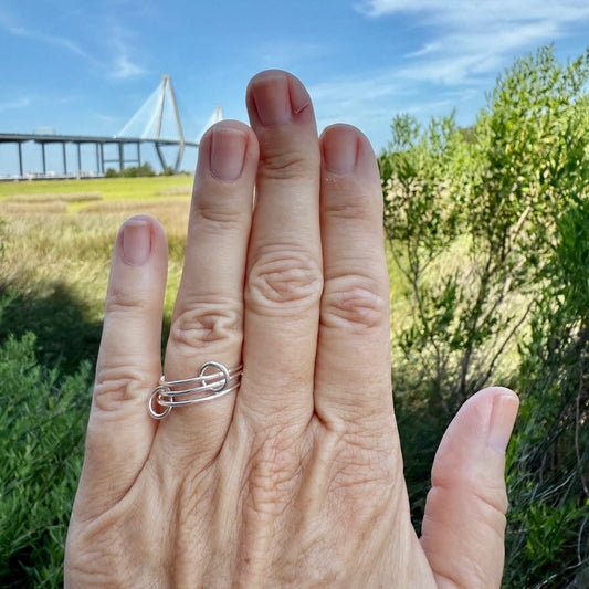 Woman's hand showing a thin interlocking ring.