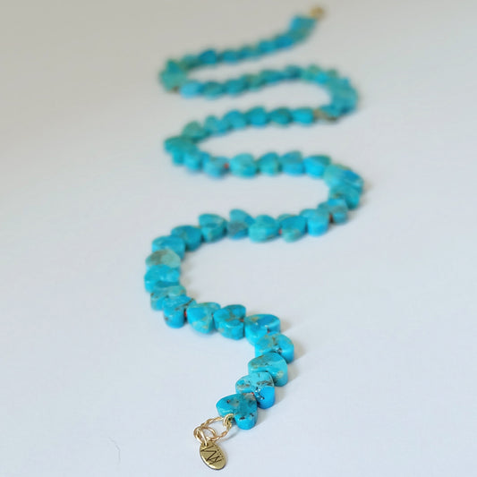 Close-up of a turquoise heart necklace featuring Kingman turquoise beads and a 14K gold clasp.