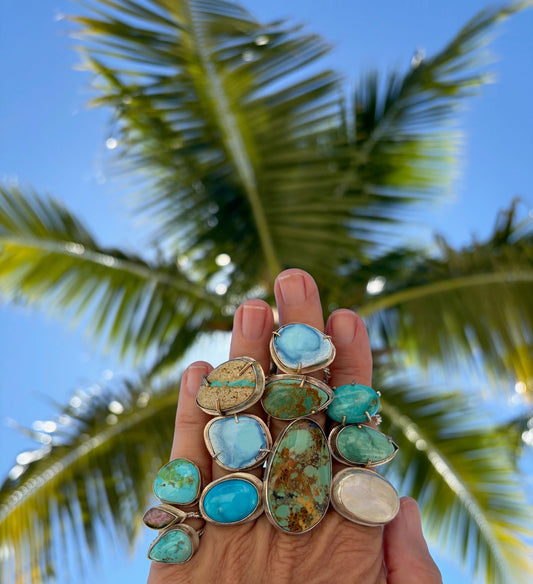 A collection of turquoise rings artistically arranged, showcasing vibrant blue hues and unique patterns.