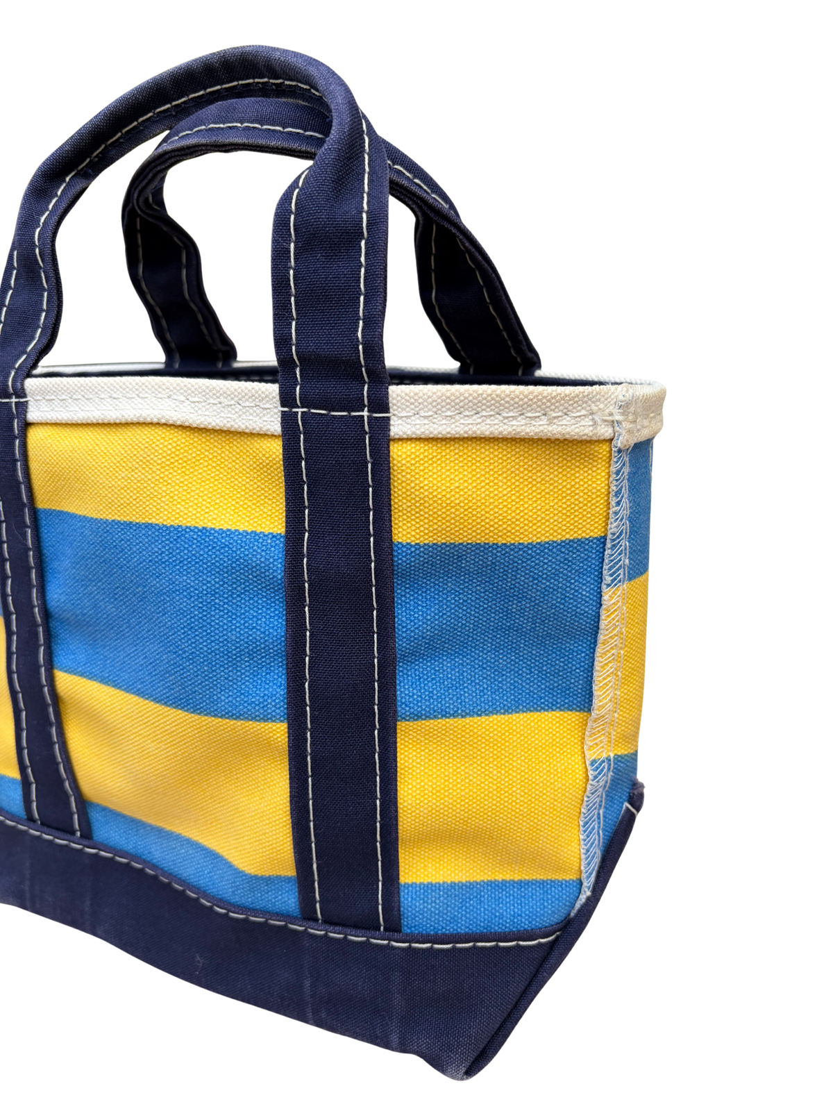 Angled top down three quarter view of Vintage L.L. Bean Tote — Mini Navy and yellow rugby Stripe canvas bag showing the opening.