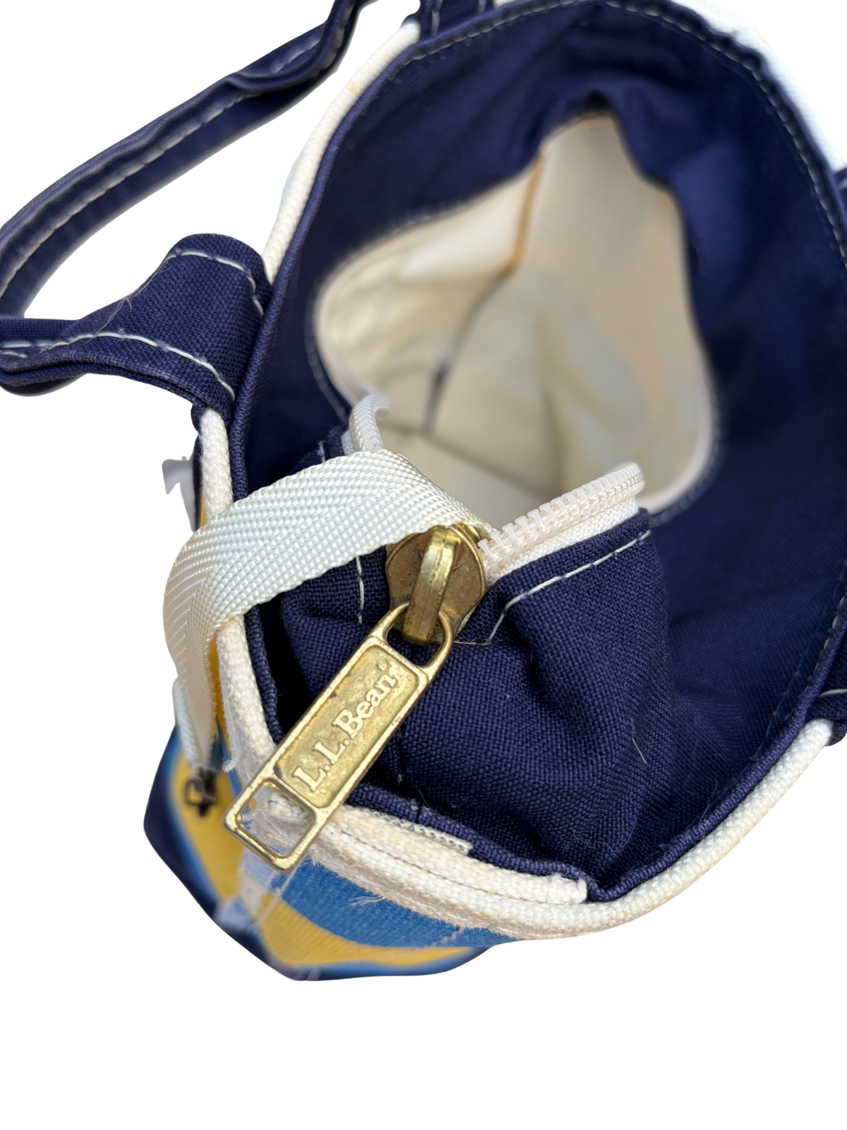 Close up interior view of Vintage L.L. Bean Tote — Mini Navy and yellow rugby Stripe showing the white manufacturing tag and canvas key strap.