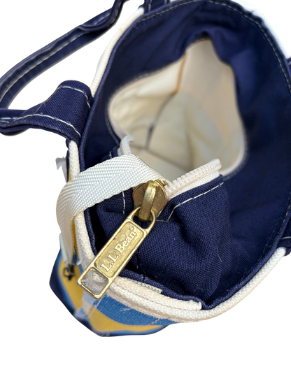 Close up interior view of Vintage L.L. Bean Tote — Mini Navy and yellow rugby Stripe showing the white manufacturing tag and canvas key strap.