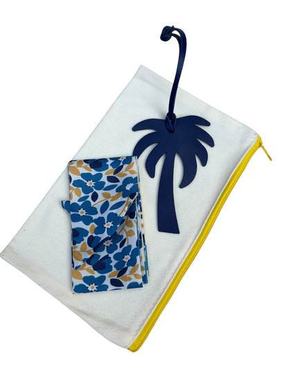 Detailed close-up of a white leather tropical palm tree bag charm attached to the handle of a Vintage L.L. Bean Tote — Mini Navy and yellow rugby Stripe.