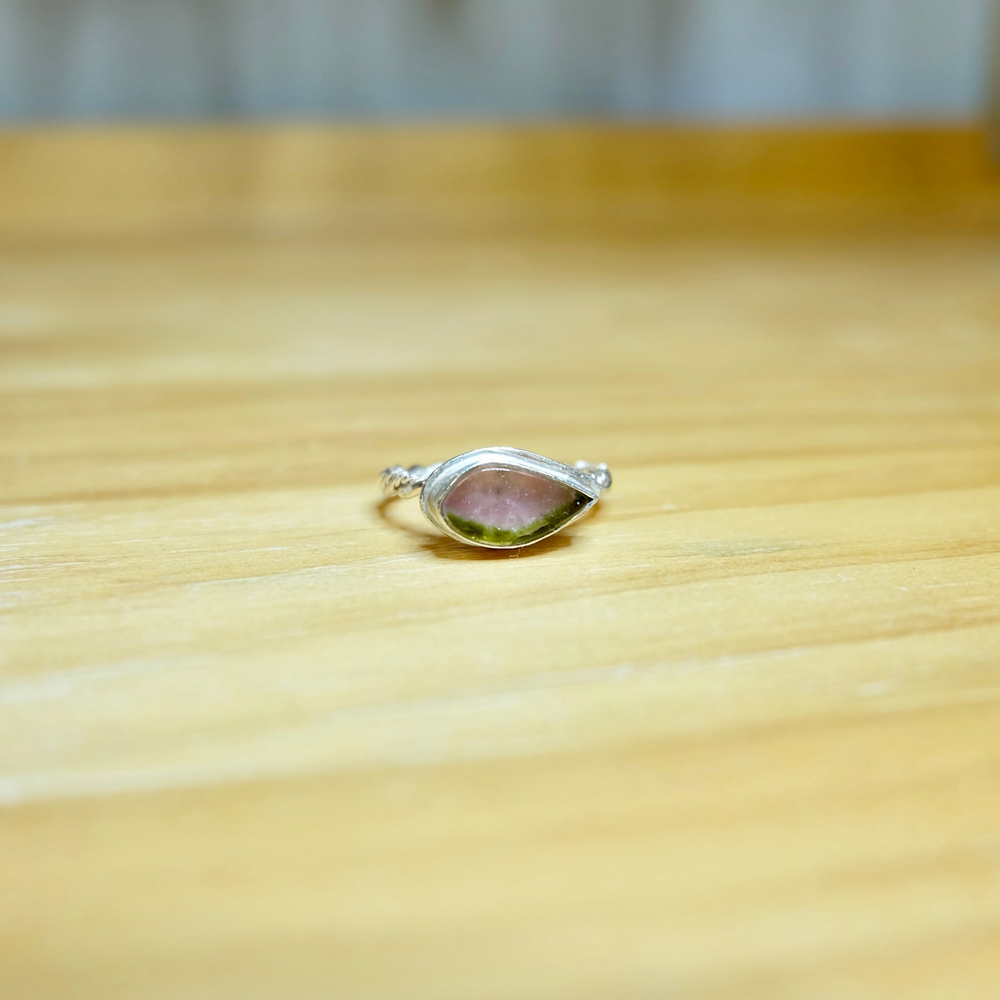 A stunning watermelon tourmaline ring featuring a vibrant pink and green gemstone set in a delicate sterling silver band.
