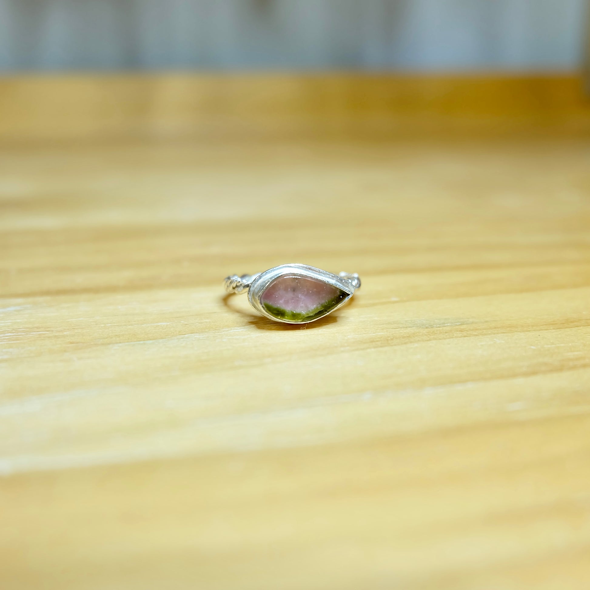A stunning watermelon tourmaline ring featuring a vibrant pink and green gemstone set in a delicate sterling silver band.