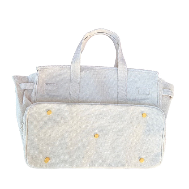 White Boatkin bag bottom showing gold feet on a white background. 