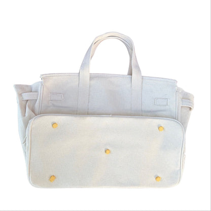 White Boatkin bag bottom showing gold feet on a white background. 