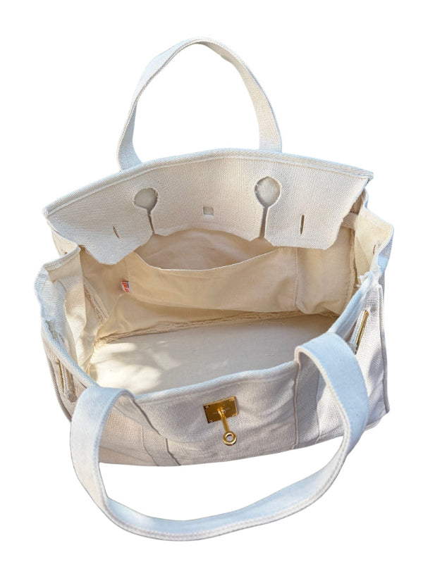Top down interior view of an open cream white Boatkin boat tote bag showing the light blue lining and inner pocket.