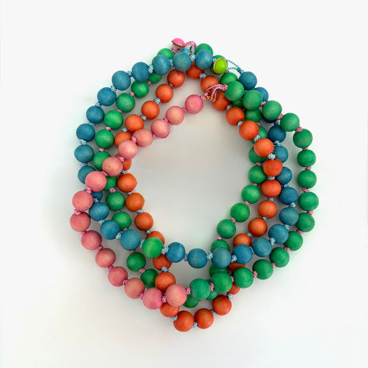 Display of wood bead necklace on a white background