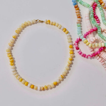 Yellow and white opal beaded candy necklace on a light background