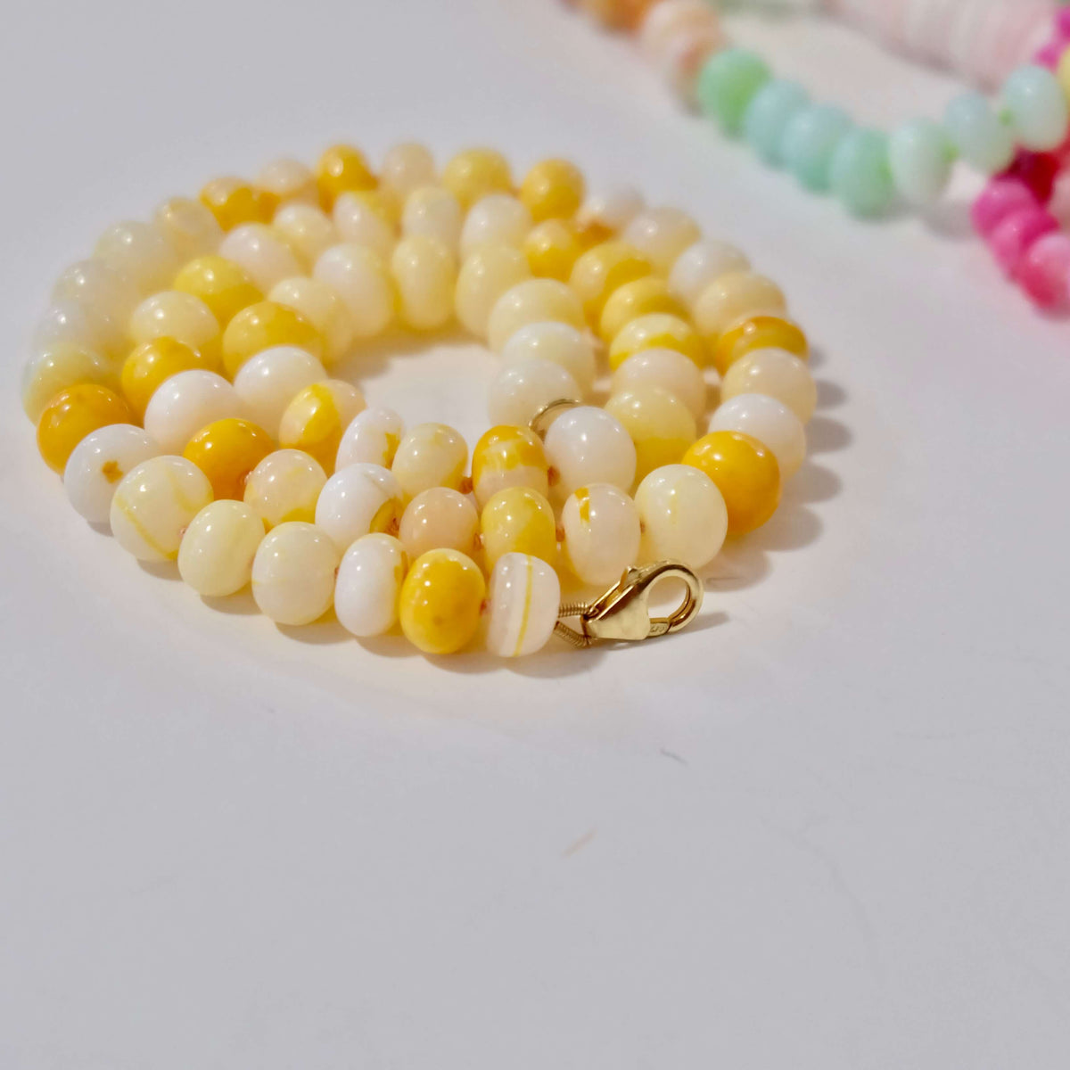 Close-up of 8mm yellow opal beads hand-knotted on coral silk